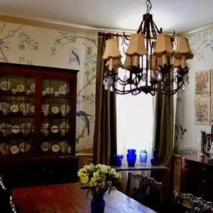 A dining room featuring an elegant chandelier above a table, showcasing the work of top mural artists in the UK.